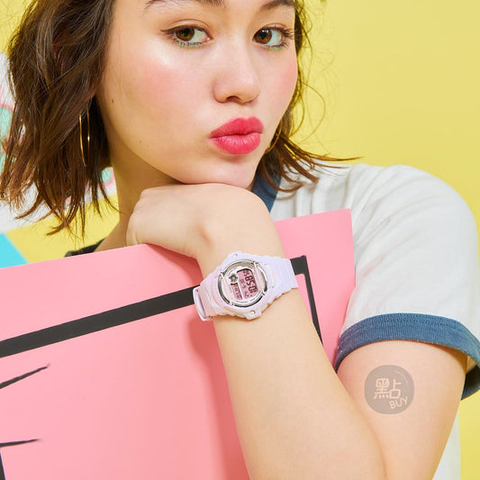 CASIO BG-169M-4DR BABY-G 女裝手錶 樹脂玻璃 粉紅色 - 佩戴於手腕特寫,黃色背景時尚生活照