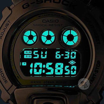 CASIO GM-6900G-9DR G-SHOCK 數碼金色錶盤男士手錶 - 錶面特寫，黑暗中藍綠色背光照明